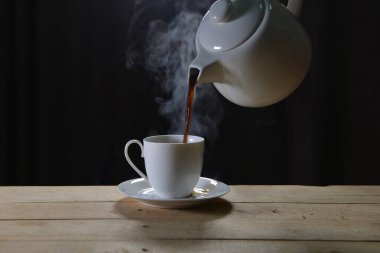 Koyu arka planda buharla çevrili sıcak kahve. Siyah kahve espresso.