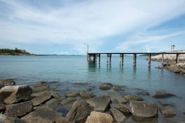 Kayalıklı deniz köprüsü ve arka planda bulutlu gökyüzü