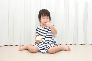 Asyalı tatlı küçük kız evde dondurmasının tadını çıkarıyor..