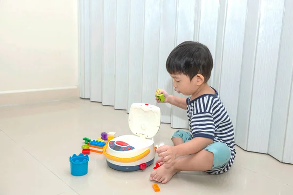 Симпатичный Мальчик Сидящий Полу Играющий Дома Разноцветными Игрушками — стоковое фото