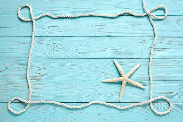 木製の青い背景に白いロープで作られたフレーム. — ストック写真