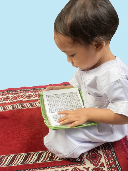 Muslim boy in a dress  reading the Koran , isolate background — Stock Photo, Image