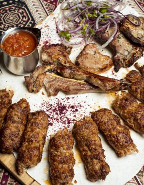 Et sığır lambakebap çeşitleri sıcak domates barbekü sos ve soğan ile servis.