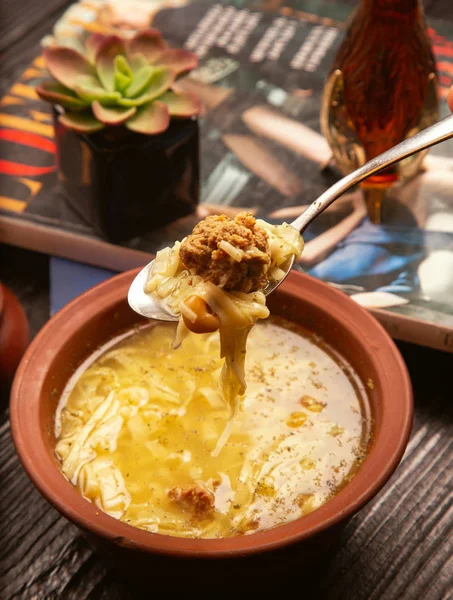Caldo de albóndigas, sopa de espaguetis, fideos en tazón de cerámica y cuchara . — Foto de Stock