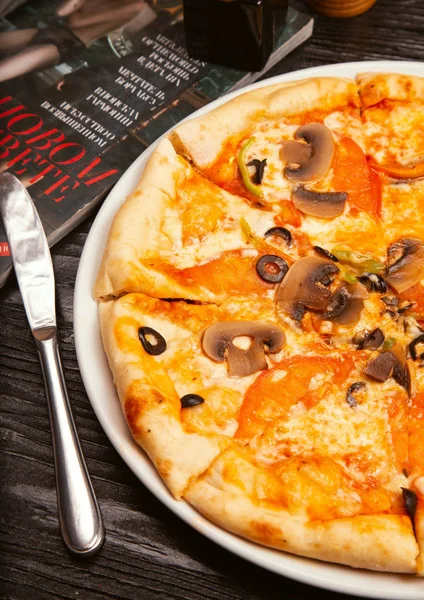 Pizza margarita with black olives, mushrooms.