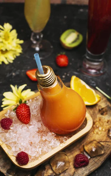 Botellas de vidrio bombilla con zumo de naranja fresco — Foto de Stock