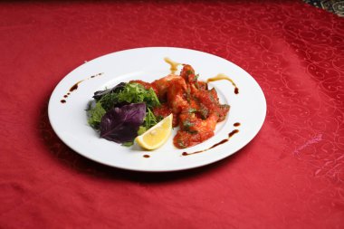 Taze domates soslu tavuk güveç ve yeşil maydanoz ve bazilik ile servis.