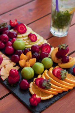 Egzotik bir meyve tabağı ve bir bardak mojito. 