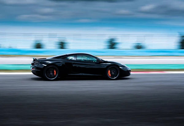 Black cabriolet sport sedan car side view driving on the highway, nature background. — Stock Photo, Image