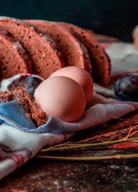 Beyaz havlu üzerinde dilimlenmiş ev yapımı sağlıklı siyah ekmek, yumurta ve erik.