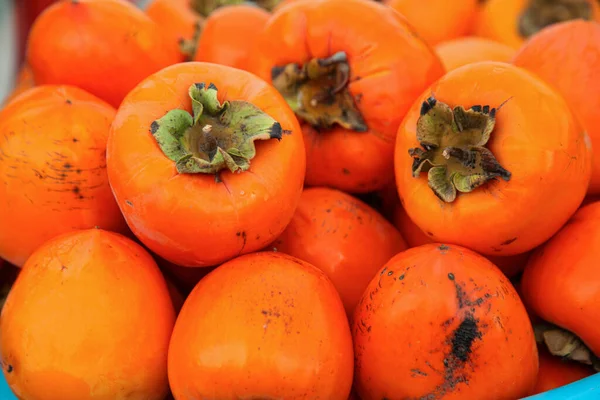 Orange color date plums with green leaves