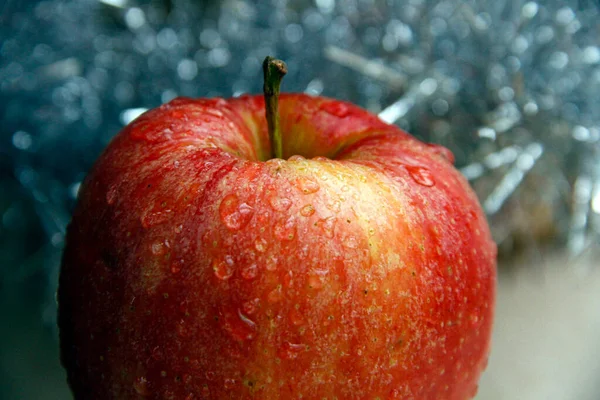 Ein roter Apfel mit gelben Punkten auf blauem Hintergrund — Stockfoto