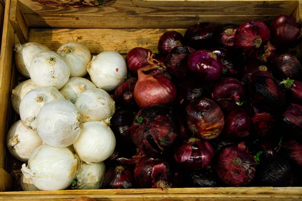 Oignons rouges et blancs dans un plateau en bois, vue sur le dessus — Photo