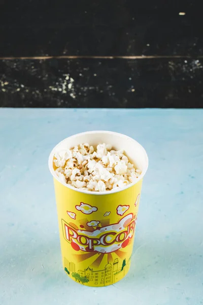Popcorns em uma caixa amarela no fundo preto — Fotografia de Stock