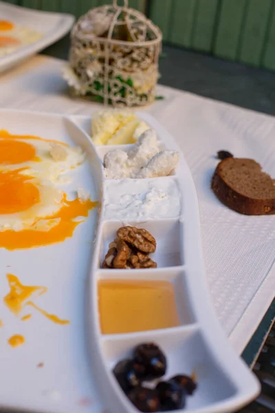 Жареные яйца с сыром и различные варенья в белом блюде — стоковое фото