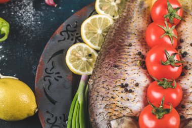 Limonlu çiğ balık ve doğranmış otlu domates.