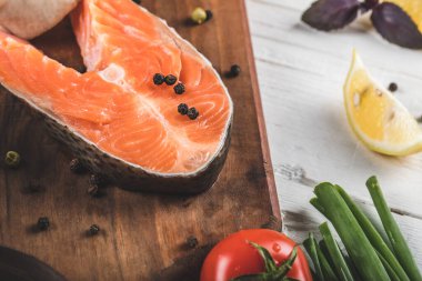 Beyaz bir masada biber ve limonlu somon fileto dilimi.