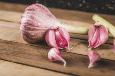 Tahtada pembe sarımsaklı eldivenler.