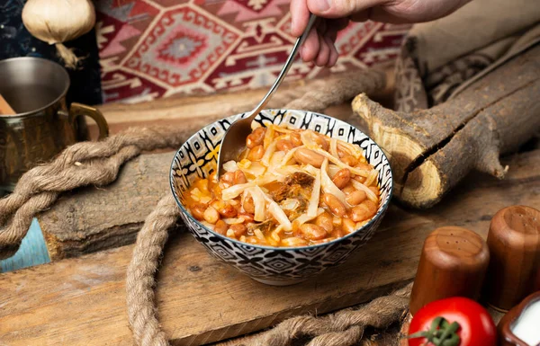 Frijoles caucásicos tradicionales con arroz y pasta tomando comida con una cuchara — Foto de Stock