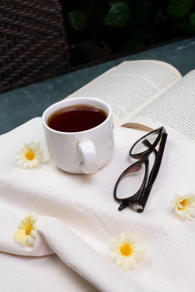 Une tasse de thé, des verres optiques et un livre — Photo