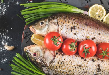 Mavi masada limon, dolma biber ve biber ile servis edilen bitkisel ve sebzeli balıklar.