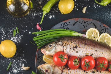 Çiğ balık fileto otlar ve sebzeler kırsal bir tabakta.