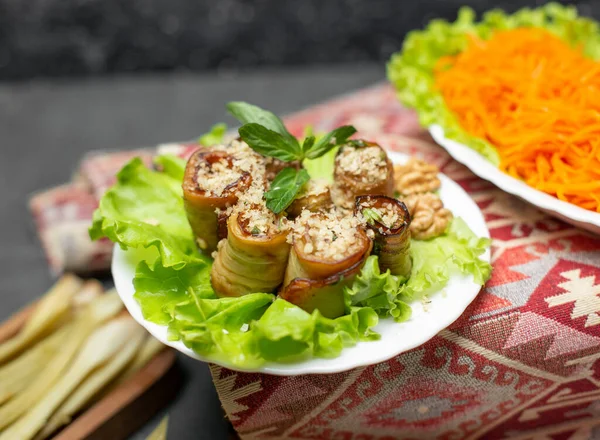 Fried eggplant roll salad in white plate on a carpet — Stock Photo, Image