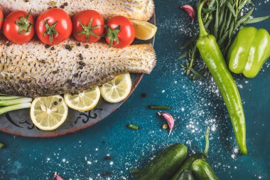 Mavi masada otlu, domatesli ve limonlu tam balık.