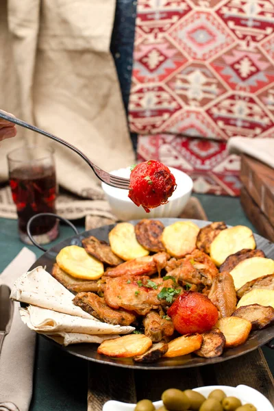 Caucasian sac ichi with meat and potatoes served with lavash bread — Stock Photo, Image