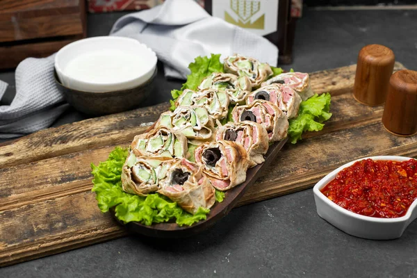 Roll salad in lavash bread on a lettuce leaf served with tomato paste — Stock Photo, Image