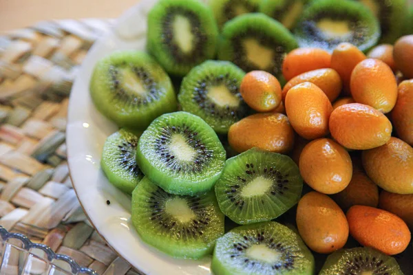 Sliced kiwi and kinkan fruits in a plate — Stock Photo, Image