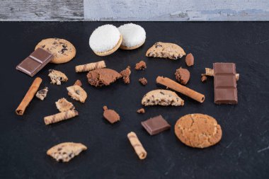 Çikolata ve bisküvi siyah masada.