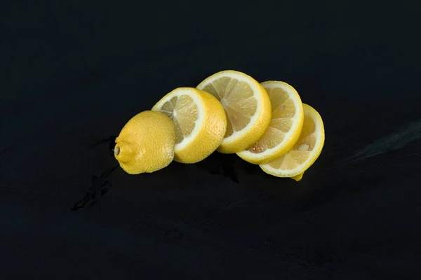 Limones en rodajas aislados en una pizarra negra —  Fotos de Stock