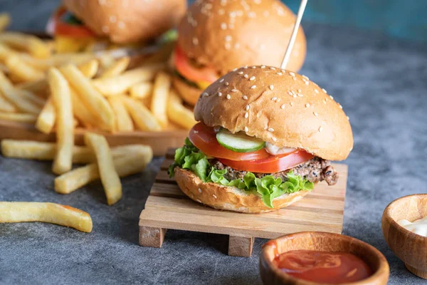 Burgers with french fries and sauces — Stock Photo, Image