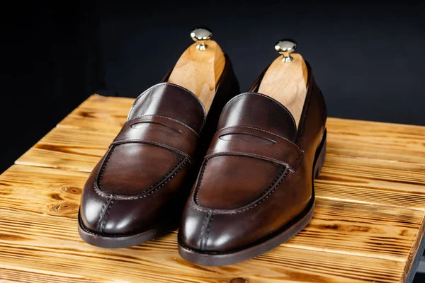 Mocassins masculinos castanhos com uma sola preta sobre fundo preto — Fotografia de Stock