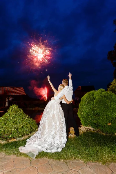Nygifta tittar på en salut på ett bröllop. — Stockfoto