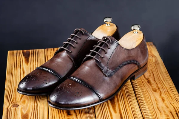 Стильне шкіряне коричневе взуття на темному фоні . — стокове фото