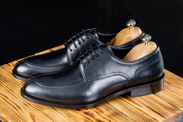 Snygg läder svarta skor mot en mörk bakgrund. Royaltyfria Stockfoton