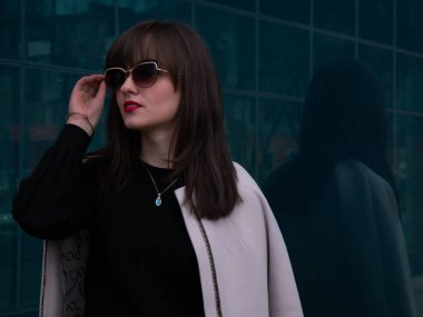 Güneş gözlüğü ve açık renkli ceket şık bayan (orta çekim)