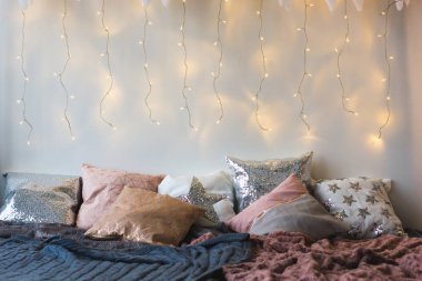 Xmas sabah yatak odasında. Çift Kişilik Yatak Noel beyaz duvar iç arka plan ile rahat ışıklar. Hediye kutusu yatakta. Yatak birçok yastıklar