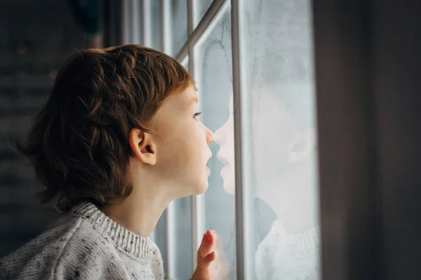 Niño esperando a Santa Claus. Lindo niño rizado sentado cerca de la ventana —  Fotos de Stock
