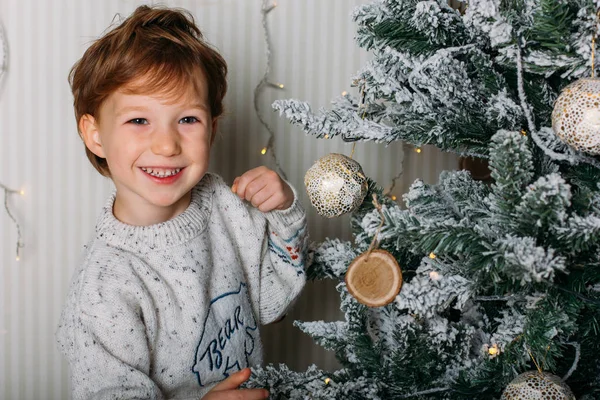 Criança bonito decorar árvore de Natal com brinquedos de madeira — Fotografia de Stock