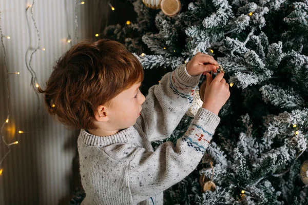 Criança bonito decorar árvore de Natal com brinquedos de madeira — Fotografia de Stock