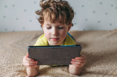Tablet vasıl bakarak yürümeye başlayan çocuk. Eğitim, gadget, bağımlılık, teknoloji, bağımlılık, çocuk görme, çocuk kavramı yetiştirme