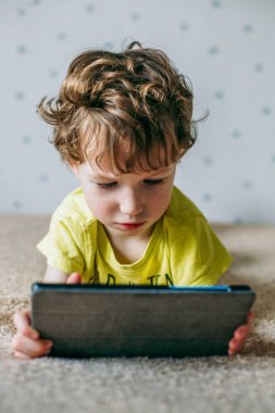 Tablet vasıl bakarak yürümeye başlayan çocuk. Eğitim, gadget, bağımlılık, teknoloji, bağımlılık, çocuk görme, çocuk kavramı yetiştirme