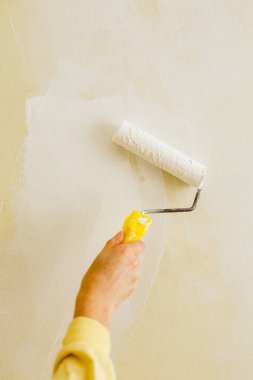 Bir duvar boya silindiri ile boyama ressam kolu kapatın. Kopya alanı, dikey fotoğraf