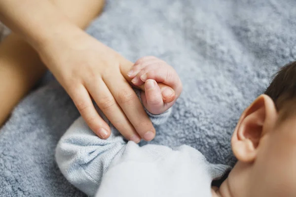 Mano de bebé sosteniendo dedo mamá. Enfoque seleccionado. Niño recién nacido — Foto de Stock