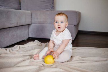 Elma ile katta oturan bebek