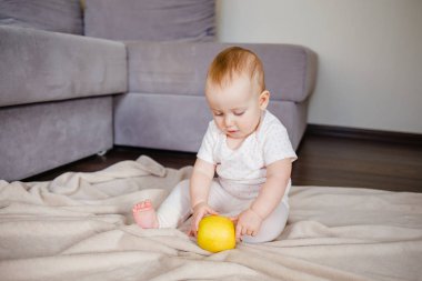 Elma ile katta oturan bebek