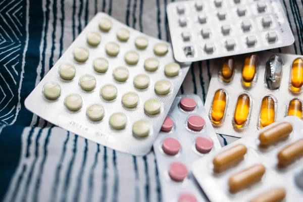 Assorted pharmaceutical medicine pills, tablets and capsules. Pills on lifestile background background. Heap of assorted various medicine tablets and pills different colors.